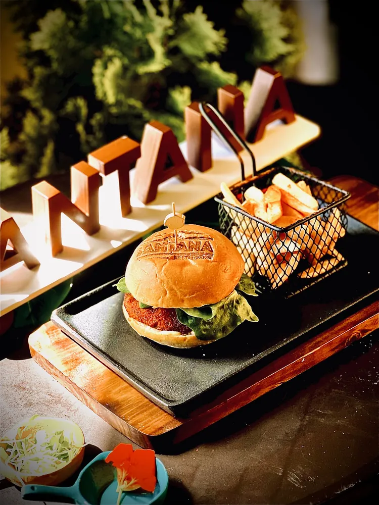 Hamburguesa de Santana con papas, presentada con las letras de madera de la casa