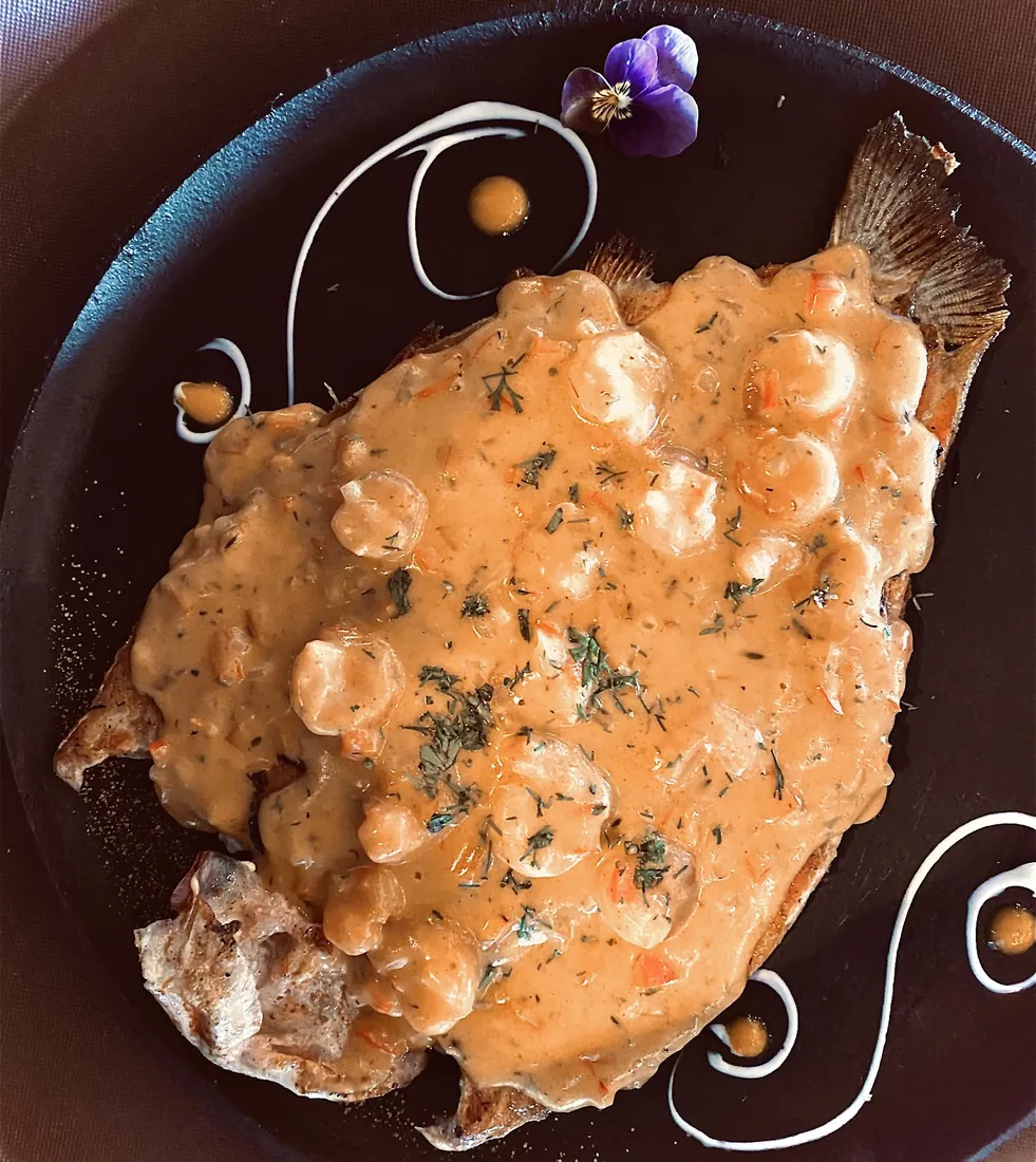 Trucha en salsa de mariscos con flores comestibles